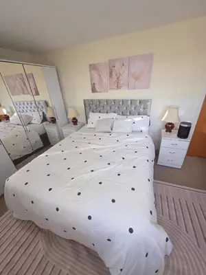 a large white bed in a bedroom with two lamps at The Jet Nest in Moffat