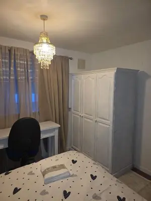 a bedroom with a bed and a desk and a chandelier at The Jet Nest in Moffat