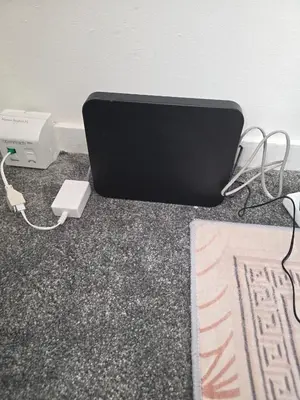 a laptop computer sitting on the floor with a charger at The Jet Nest in Moffat