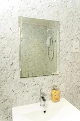 a mirror above a sink in a bathroom at 2 bed flat near Livingston North Station in Livingston