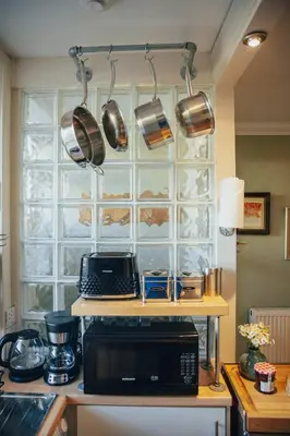 a kitchen with a microwave and pots and pans at Snug 1 Bed Apartment in Edinburgh's Juniper Green in Edinburgh