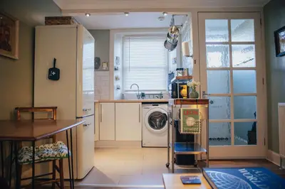 a kitchen with a washer and a washing machine in it at Snug 1 Bed Apartment in Edinburgh's Juniper Green in Edinburgh