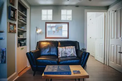 a living room with a leather couch and a coffee table at Snug 1 Bed Apartment in Edinburgh's Juniper Green in Edinburgh