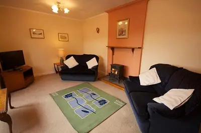 a living room with a couch and a chair at Correay Cottage in Salen