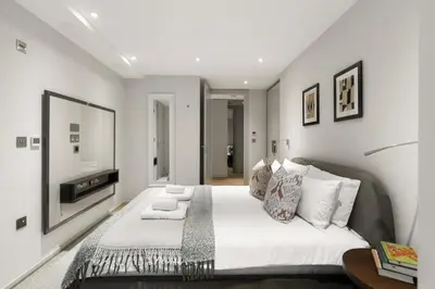 a bedroom with a large bed and a mirror at Stylish 2-Bedroom Flat On Seven Sisters Rd in Moffat