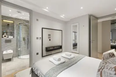 a bedroom with a large bed and a shower at Stylish 2-Bedroom Flat On Seven Sisters Rd in Moffat