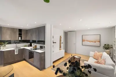 a kitchen and living room with a couch and a table at Stylish 2-Bedroom Flat On Seven Sisters Rd in Moffat