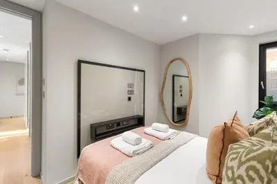 a bedroom with a mirror and a bed with towels at Bright 3BR London Flat w Full Kitchen in Moffat