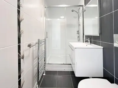a bathroom with a shower and a toilet and a sink at Stunning River View City Centre Apartment in Glasgow