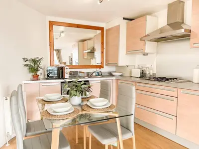 a kitchen with a glass table and chairs in it at Stunning River View City Centre Apartment in Glasgow