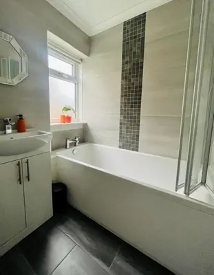 a white bathroom with a tub and a sink at Clyde Fifty Two - Glasgow Apartment in Glasgow