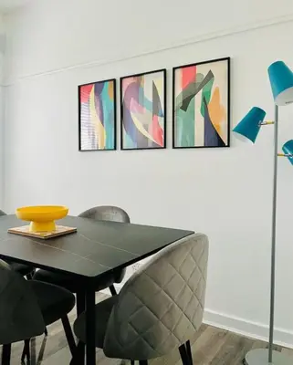a dining room table and chairs with paintings on the wall at Clyde Fifty Two - Glasgow Apartment in Glasgow