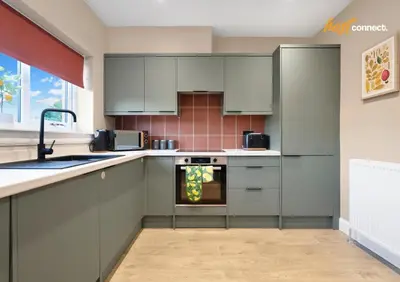 a kitchen with white cabinets and a sink at 3Bed House I Sleeps 6 I Dunfermline in Dunfermline