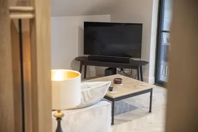 a living room with a television and a table at Highland House in Lochearnhead