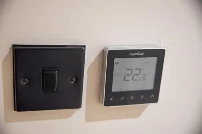 an alarm clock on a wall with a clock on it at Highland House in Lochearnhead