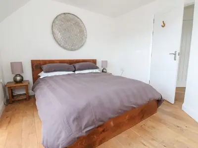 a bedroom with a large bed with a wooden headboard at Sealladh in Appin