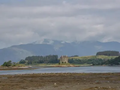 a castle in the middle of a body of water at Sealladh in Appin