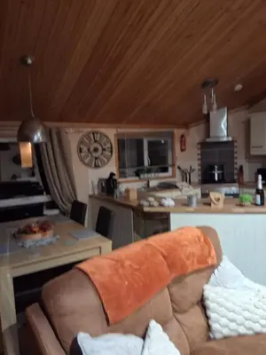 a living room with a couch and a kitchen at Redwood lodge with luxury hot tub at Three lochs holiday park in Balminnoch