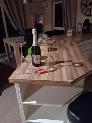 a table with a bottle of wine and two wine glasses at Redwood lodge with luxury hot tub at Three lochs holiday park in Balminnoch