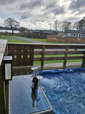 a pool of water with a bottle in it at Redwood lodge with luxury hot tub at Three lochs holiday park in Balminnoch