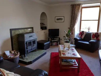 a living room with a couch and a fireplace at Holiday Home Benmore Farm House in Stirling mit Bergblick by Interhome in Crianlarich
