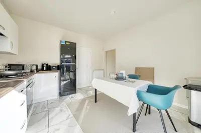 a kitchen with a white table and blue chairs at Stylish and Morden 3Bed House Glasgow City Centre in Glasgow