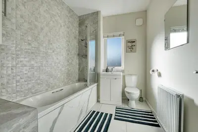 a bathroom with a tub and a toilet and a sink at Stylish and Morden 3Bed House Glasgow City Centre in Glasgow