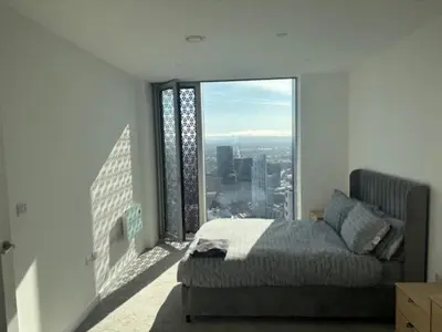 a bedroom with a bed and a large window at Skyline view 2 bedroom apartment in Moffat