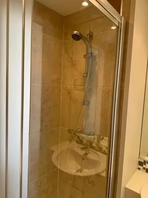a glass shower with a sink in a bathroom at Regents House, ground floor apartment with sea views in Moffat