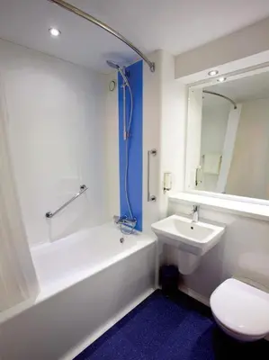 a bathroom with a tub and a sink and a toilet at Travelodge Edinburgh Dreghorn in Edinburgh