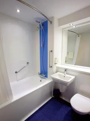a bathroom with a tub and a sink and a toilet at Travelodge Edinburgh Dreghorn in Edinburgh