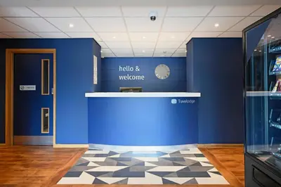 a room with a blue wall and a clock on the wall at Travelodge Falkirk in Polmont