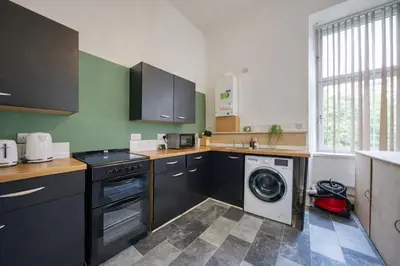 a kitchen with a washing machine and a washer at Group Stay 4BR Sleeps 11 Spacious with Parking in Glasgow