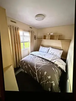 a bedroom with a bed in a small room at Sandylands caravan park in Stevenston