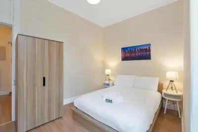 a bedroom with a white bed and a door at Charming City View Apartment with Modern Comforts in Edinburgh
