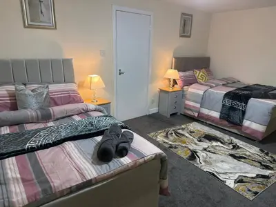 a bedroom with two beds with shoes laying on the bed at Cosy Retreat - Suite 5 in Hamilton