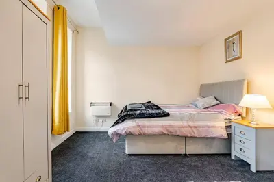 a bedroom with a bed and a desk and a window at Cosy Retreat - Suite 5 in Hamilton