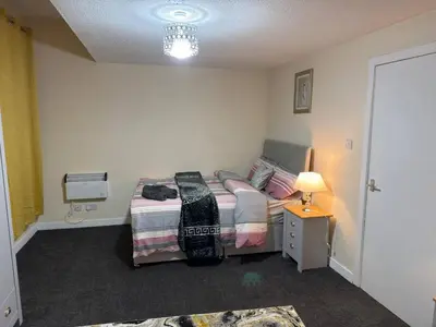 a bedroom with a bed and a table with a lamp at Cosy Retreat - Suite 5 in Hamilton