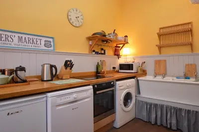 a kitchen with a washing machine and a sink at Montford Shore in Rothesay