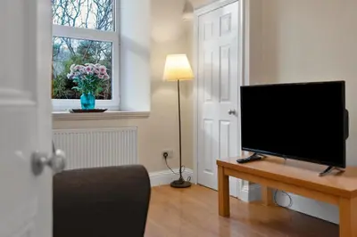 a living room with a flat screen tv on a table at Great location Edinburgh city centre in Edinburgh