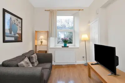 a living room with a couch and a flat screen tv at Great location Edinburgh city centre in Edinburgh