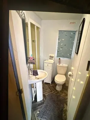 a small bathroom with a toilet and a sink at Sandylands caravan park in Stevenston