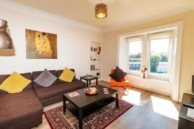 a living room with a couch and a table at Mycosyapartment 47 in Paisley