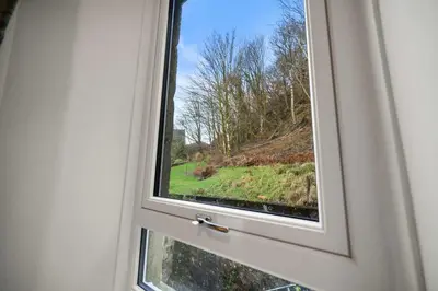 a window with a view of a green field at Stylish 1BR Central Oban Retreat in Oban