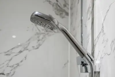 a shower head in the corner of a bathroom at The Nook - Beachwalk Apartments in Ayr