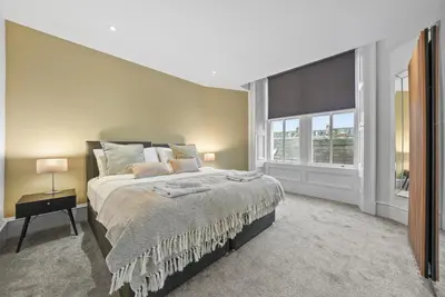 a bedroom with a large bed and a window at The Nook - Beachwalk Apartments in Ayr