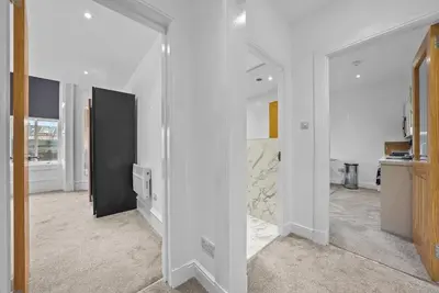 a room with white walls and a hallway with a door at The Nook - Beachwalk Apartments in Ayr