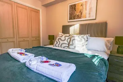 a bedroom with a bed with two towels on it at Burnvale Apartment in Livingston