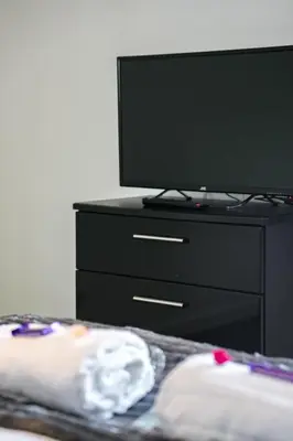 a black dresser with a flat screen tv on top at Jake's House in Airdrie