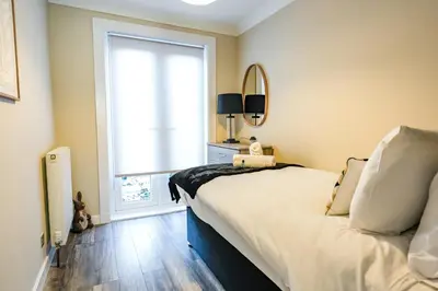 a bedroom with a large bed and a window at Ochil View House in Falkirk